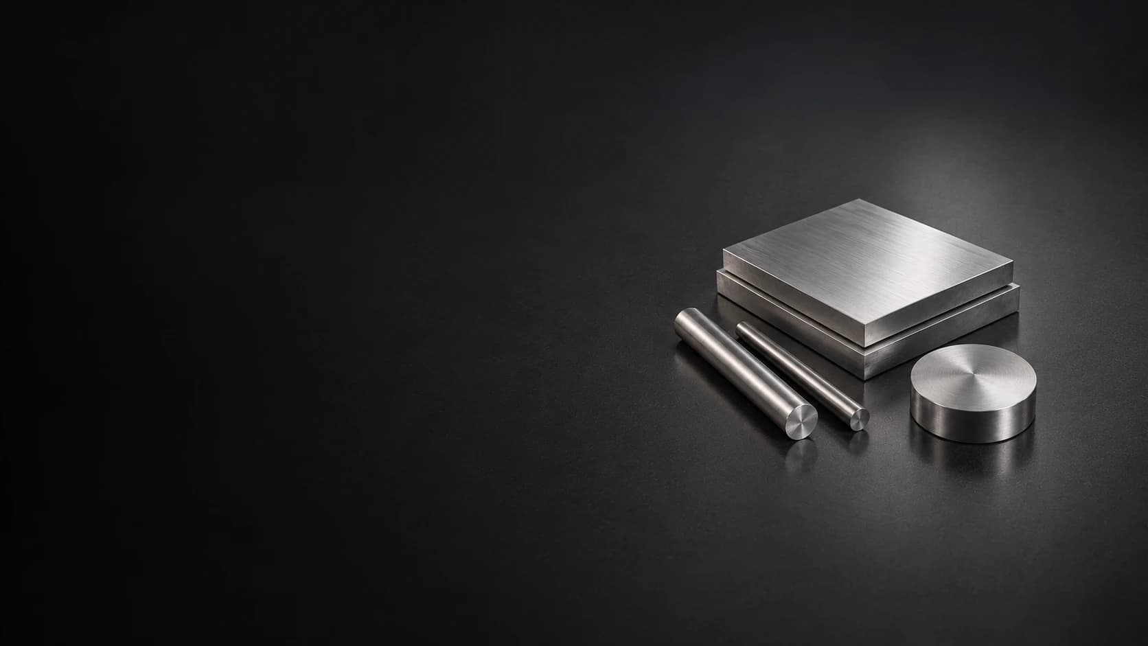 Small finished plates and bars arranged on a dark graphite surface